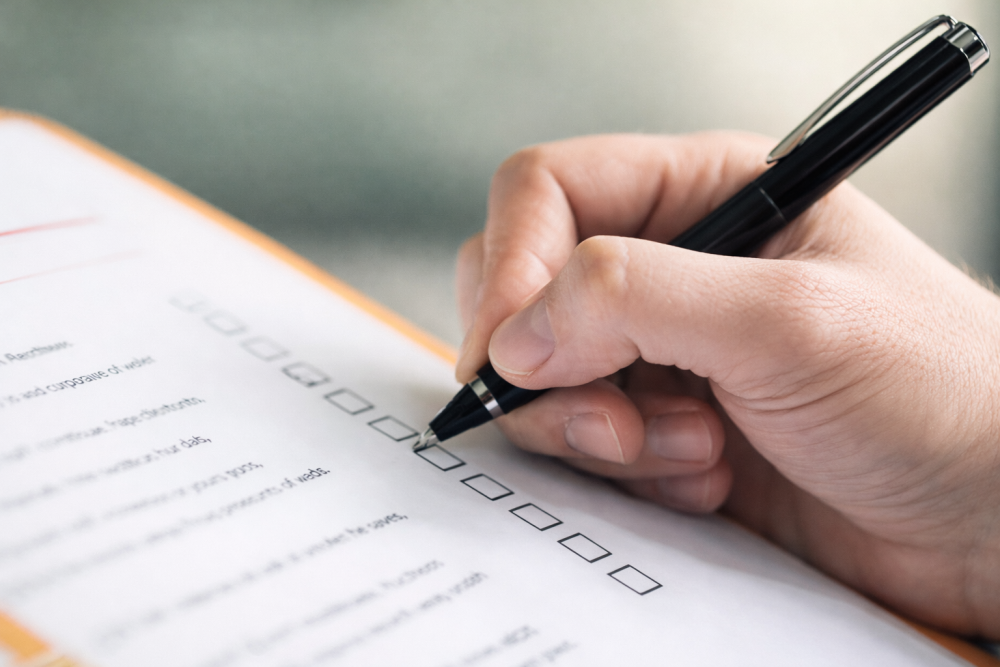 Hand completing a home safety assessment checklist in a Toronto home