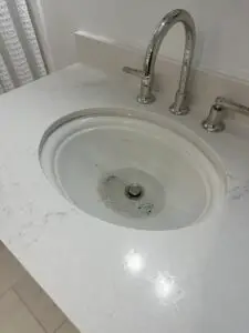Bathroom sink with visible hair and soap buildup before cleaning during a Good Company maintenance visit