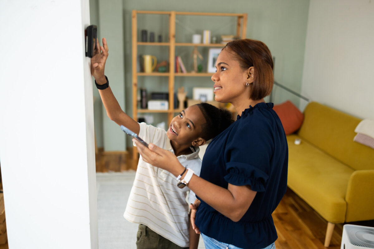 Parent showing child how home alarm panel works before staying home alone