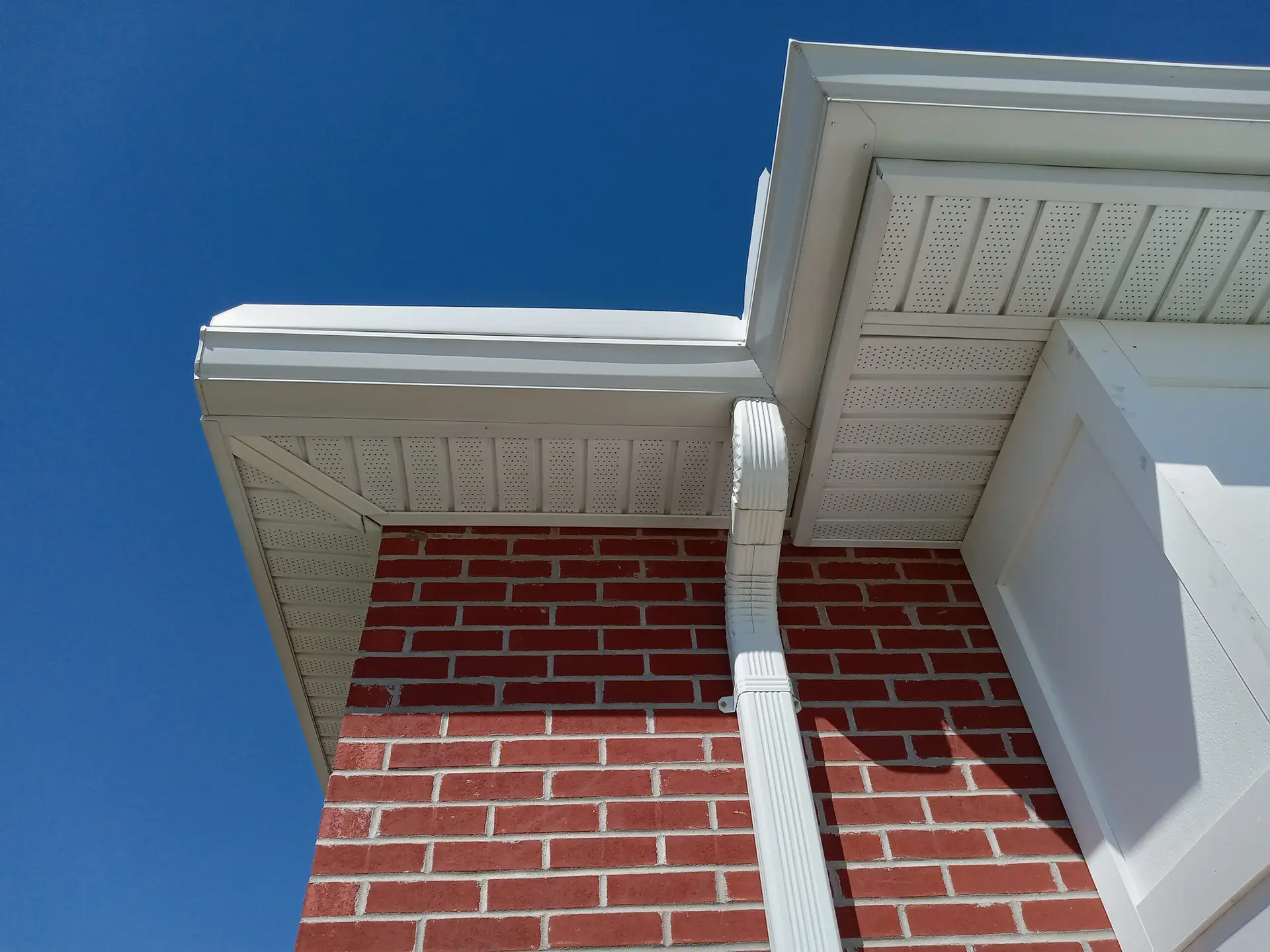 Exterior soffit, fascia and downspout detail on a Toronto brick home showing roof edge drainage system