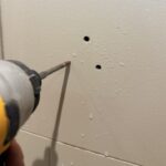 Drilling through bathroom tile for grab bar installation using a diamond drill bit and water cooling