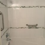 Grab bar installation in Toronto bathtub with vertical entry bar and horizontal grab bar with tray on tiled wall