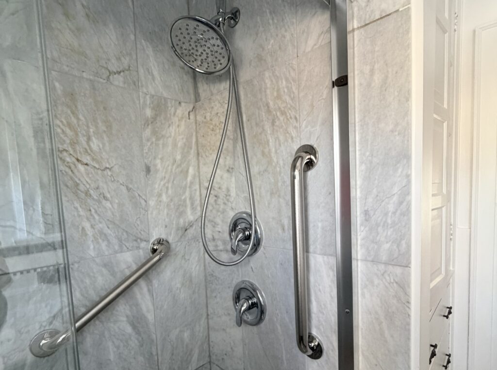 Grab bar installation in Toronto shower with vertical and horizontal safety bars on tile wall
