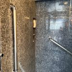 Vertical grab bar installed in luxury granite walk-in shower for bathroom safety and accessibility in Toronto