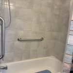 Horizontal grab bar installed in bathtub shower for bathroom safety and accessibility in Toronto home