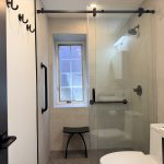 Matte black grab bars installed in a walk-in shower with built-in seating to improve bathroom safety and accessibility.