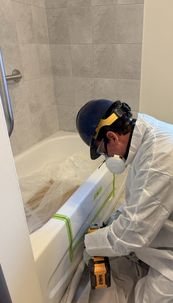 Diamond blade cutting a steel bathtub during a bathtub cutout installation in Toronto