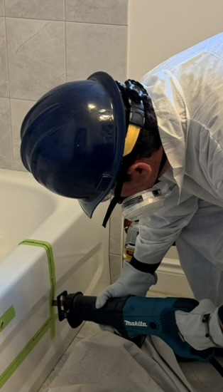 Reciprocating saw cutting a steel bathtub during a bathtub cutout installation in Toronto