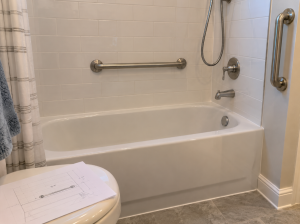 Grab bars installed in a residential bathtub following a home accessibility plan